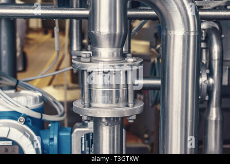 Anschluss der Rohre aus rostfreiem Stahl, mit Schrauben. Brillante Oberflächen. Stockfoto