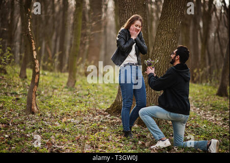 Love Story von Cool gemischtrassiges Paar im Frühjahr Wald. Heiratsantrag arabischen Mann zu europäischen Mädchen. Stockfoto