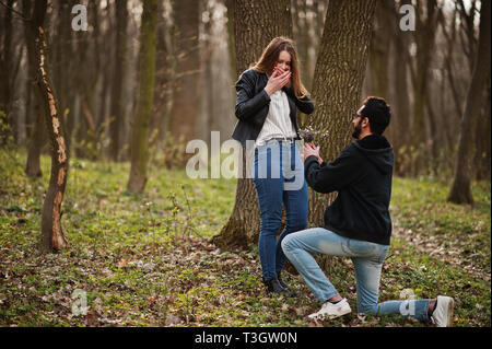 Love Story von Cool gemischtrassiges Paar im Frühjahr Wald. Heiratsantrag arabischen Mann zu europäischen Mädchen. Stockfoto