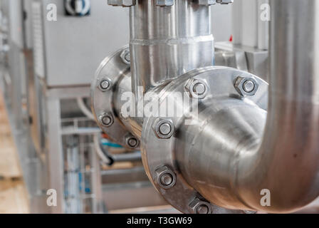 Anschluss der Rohre aus rostfreiem Stahl, mit Schrauben. Brillante Oberflächen. Stockfoto