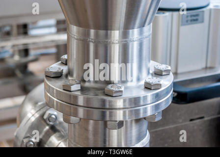 Anschluss der Rohre aus rostfreiem Stahl, mit Schrauben. Brillante Oberflächen. Stockfoto
