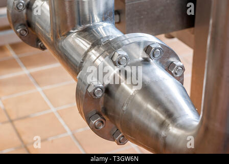 Anschluss der Rohre aus rostfreiem Stahl, mit Schrauben. Brillante Oberflächen. Stockfoto
