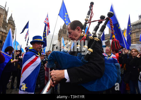 Alastair Campbell spielt Dudelsack durch Demonstranten außerhalb des Houses of Parliament in Westminster umgeben. Stockfoto