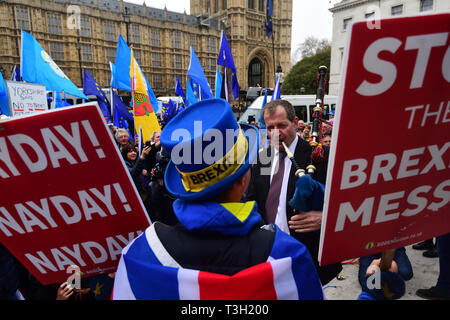 Alastair Campbell spielt Dudelsack durch Demonstranten außerhalb des Houses of Parliament in Westminster umgeben. Stockfoto