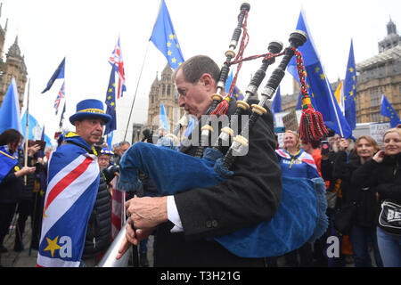 Alastair Campbell spielt Dudelsack durch Demonstranten außerhalb des Houses of Parliament in Westminster umgeben. Stockfoto