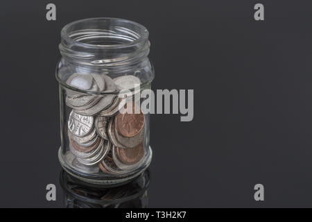 Glas Glas mit UK-Münzen - als Metapher für die persönlichen Ersparnissen, regnerischer Tag sparen, Altersvorsorge Topf, Topf. Stockfoto