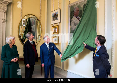 Der Prinz von Wales (dritter von links) präsentiert ein neues Portrait von sich selbst durch lokale Künstler Gareth Reid (rechts) bei einem Besuch in Hillsborough Schloss und Gärten mit der Herzogin von Cornwall (links), vor der Öffentlichkeit Wiedereröffnung des offiziellen Wohnsitz. Auch dargestellt Bill Montgomery (zweiter von links). Stockfoto