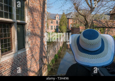Frau mit Hut mit Blick auf die Groot Begijnhof und des Flusses Dijle in Leuven, Belgien Stockfoto