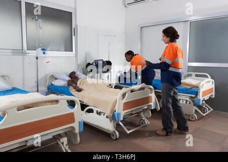 Medical Center Intensivstation mit Betten und Patienten auf Sauerstoff, tragbaren Defibrillator und Ventilator Ausrüstung plus Stationsarzt und Krankenschwester Stockfoto