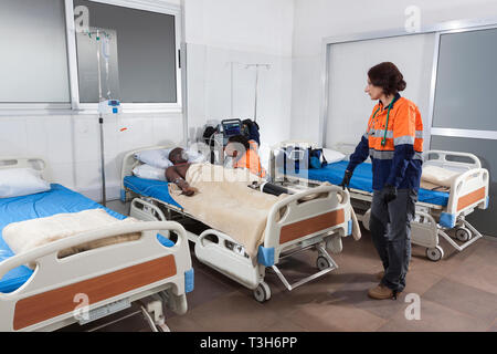 Medical Center Intensivstation mit Betten und Patienten auf Sauerstoff, tragbaren Defibrillator und Ventilator Ausrüstung plus Stationsarzt und Krankenschwester Stockfoto