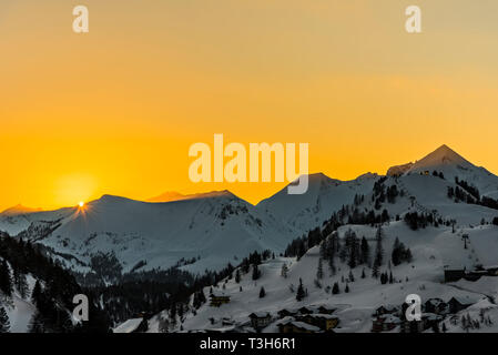 Orange Himmel bei Sonnenuntergang über den Bergen in Obertauern, Österreich Stockfoto