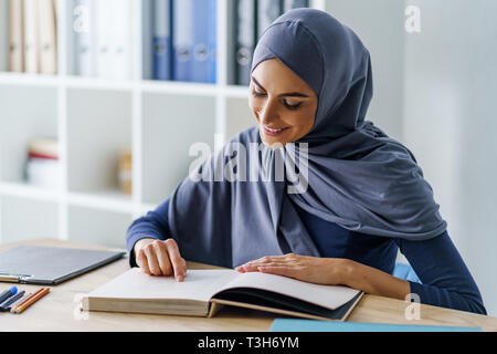 Schöne muslimische Frau lesen Stockfoto