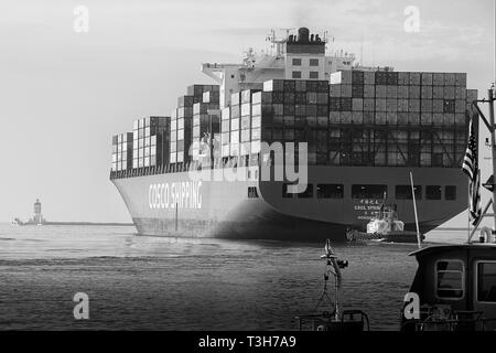 Schwarz-weiß-Stern Blick auf das Containerschiff, CSCL SPRING, als sie den Hafen von Los Angeles verlässt, den Angels Gate Lighthouse vor sich. Kalifornien Stockfoto