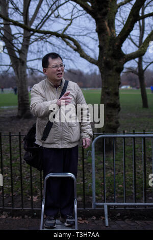 Ein straßenprediger talkling mit Leidenschaft in der Dämmerung im Dezember in einer Ecke des berühmten Lautsprecher im Hyde Park, London, in letzter Zeit eine touristische Attraktion geworden. Stockfoto