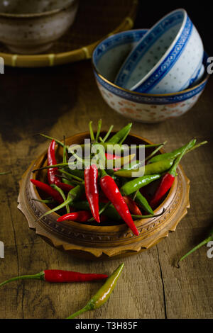 Thai rote und grüne Chilis oder Prik chee fah auch manchmal als Birds Eye Chile Pfeffer feurige Paprika auf 50.000 bis 100.000 Scoville Einheiten bewertet bekannt Stockfoto