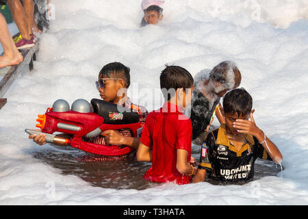 Vientiane, Laos - 16. April 2018: Kinder mit Wasserkanonen von Schaum an der Pimai neues Jahr Feier in Laos umgeben Stockfoto