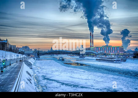 = gefrorenen Fluss Moskwa und Rostovskaya Damm im Winter Sonnenuntergang = Moskau winter Stadtbild mit Blick von Borodinsky Brücke auf dem gefrorenen Fluss Mosk Stockfoto