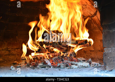 Große Feuer in Pizza Ofen, Heizung Ziegel und Gewölbe der Pizza Backofen während der Vorbereitung für neue Arbeitstag des Italienischen Restaurant Stockfoto