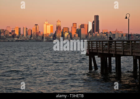 WA16104-00...WASHINGTON - die untergehende Sonne leuchtet in der Abenddämmerung auf den Hochhäusern von Seattle im Seacrest Park an der Elliott Bay, 2018. Stockfoto