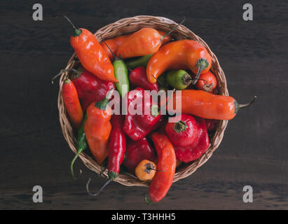 Korb mit Paprika in verschiedenen Farben und Formen. Ansicht von oben. Stockfoto