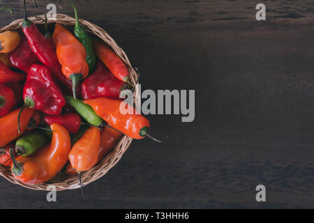 Korb mit Paprika in verschiedenen Farben und Formen. Ansicht von oben. Speicherplatz zu kopieren. Stockfoto