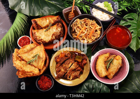 Verschiedene chinesische Gerichte. Chinesische Nudeln, gebratener Reis, Pekingente, Dim Sum, Frühlingsrollen. Berühmte chinesische Gerichte auf den Tisch. Chinesisches Restaurant Stockfoto