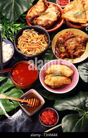 Verschiedene chinesische Gerichte. Chinesische Nudeln, gebratener Reis, Pekingente, Dim Sum, Frühlingsrollen. Berühmte chinesische Gerichte auf den Tisch. Chinesisches Restaurant Stockfoto