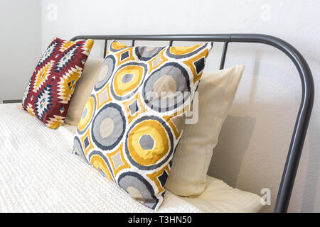 Bunte Kissen auf dem Bett im Inneren des modernen Schlafzimmer im Loft Wohnung Apartments in hellen Farben Stil Stockfoto