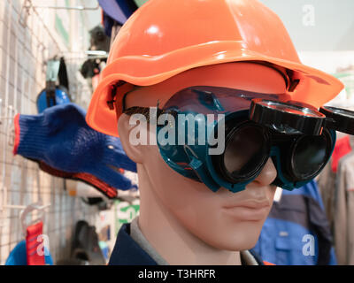 Professionelle persönliche Schutzausrüstung sicherheitstechnische Ausrüstung für Arbeitnehmer - Dummy orange Helm und Brille aus Kunststoff Stockfoto