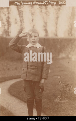 Jahrgang fotografische Postkarte zeigt ein Junge der Aufmerksamkeit stehen und Salutierte in der Zeit des Ersten Weltkriegs. "Die jungen Rekruten, Mai 1915' Stockfoto
