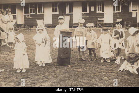 Jahrgang fotografische Postkarte mit einer Gruppe von Kindern tragen Kostüme an einer britischen Holiday Camp Stockfoto
