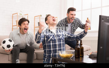 Sieger. Aufgeregt Freunde Fussball zu Hause beobachten Stockfoto