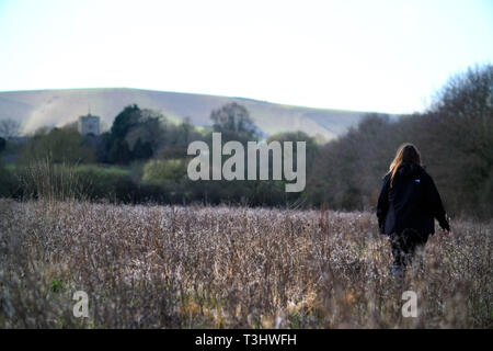 Frau wandern in einem Feld der Unkräuter Stockfoto