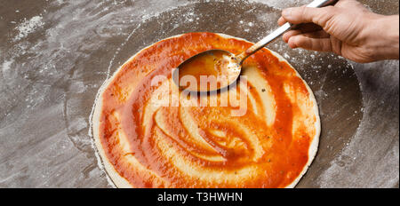 Küchenchef italienische Pizza, hinzufügen Sauce, Panorama Stockfoto