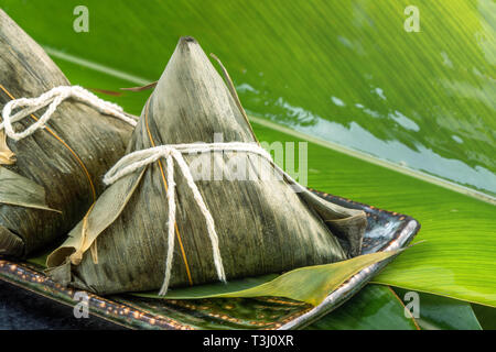 Close Up, Kopieren, berühmten chinesischen Essen in Drachenboot (duan Wu) Festival, gedämpftem Reis Knödel pyramidal geformt, die mit Bambus Blätter gemacht von Stockfoto