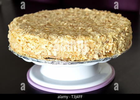 Runde vielschichtige Kuchen Napoleon mit Vanillesauce. Schwarzer Holztisch Hintergrund. Selektive konzentrieren. Stockfoto