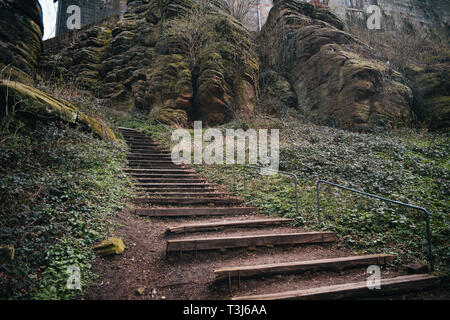 Alte Holztreppe, Treppe mit grossen Felsen Hintergrund Stockfoto