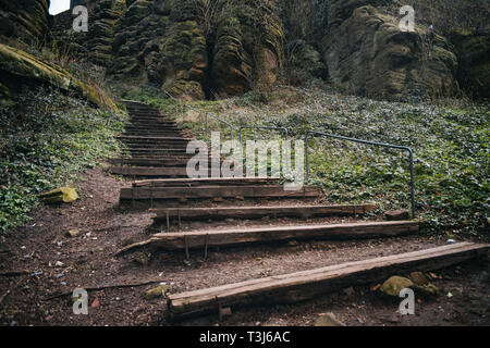 Alte Holztreppe, Treppe mit grossen Felsen Hintergrund Stockfoto