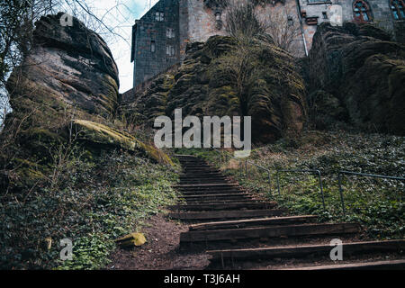 Alte Holztreppe, Treppe mit grossen Felsen Hintergrund Stockfoto