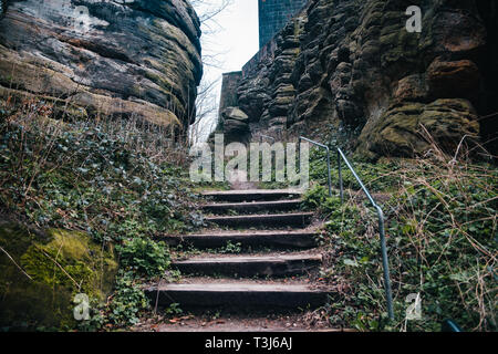 Alte Holztreppe, Treppe mit grossen Felsen Hintergrund Stockfoto