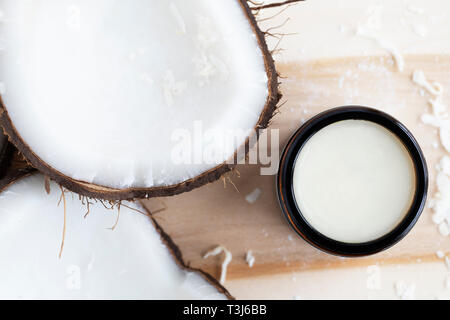 Kokosnüsse mit Kokos Kosmetik Creme von oben nach unten an. Stockfoto