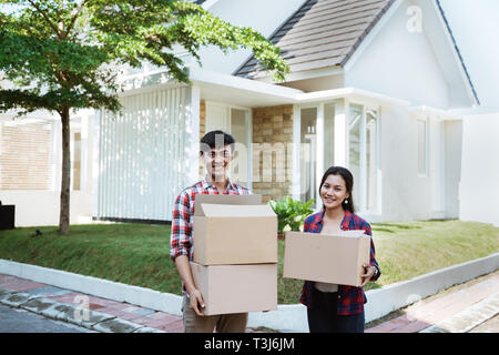 Paar Umzug in Ihr neues Haus holding Karton Stockfoto