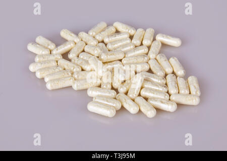 Verschüttete Kapseln auf den weißen Hintergrund. Vitamintabletten Tabletten Stockfoto