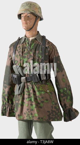 Eine reversible Camouflage smock, für die Waffen-SS auf beiden Seiten mit Nr. gedruckt 6 Platane Tarnung für den Einsatz im Frühjahr und Herbst, mit schwarzen Faden, vernickelt Knöpfe angenäht. Version für 1942 mit geraden Gesäßtaschen, teilweise in Eiche leck Tarnung, Schlaufen zur Tarnung Materialien, fünf Maschine-genähte Paar Löcher für die Brust Schnüre, mit den ursprünglichen Zugschnur. Ungetragen. Farben frisch. Vgl. Beaver", Camouflage Uniformen der Waffen-SS". Auch eine original Wehrmacht Shirt und einen schwarzen Ledergürtel mit Patrone Container und Y-Trägern. Zusammen mit einigen anderen Elemente für, Editorial-Use - Nur Stockfoto