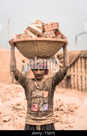 Ziegelei Arbeiter Backsteine, die in einem Korb auf dem Kopf, Dhaka, Bangladesch Stockfoto