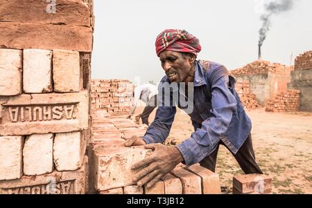 Brick Fabrikarbeiter Stapel Ziegelsteine, Dhaka, Bangladesch Stockfoto