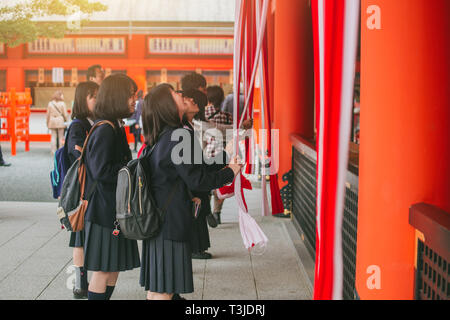 Die Menschen huldigen werfen Münzen und die Glocke zu heiligen Segen Schütteln in der japanischen Schrein. Kyoto, 13. November 2016. Stockfoto