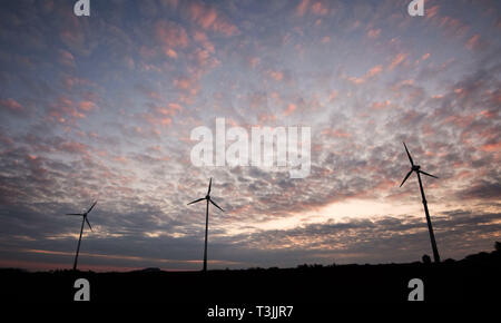 Hannover, Deutschland. 10 Apr, 2019. Windenergieanlagen heben Sie sich von der morgendlichen Himmel, die durch den Sonnenaufgang verfärbt ist. Credit: Julian Stratenschulte/dpa/Alamy leben Nachrichten Stockfoto