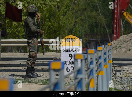 April 9, 2019 - Eine indische Armee Soldat bewacht die National Highway als militärkonvoi übergibt am Stadtrand von Srinagar, Kashmir am 10. April 2019. Die indische Regierung ein Verbot der zivilen Verkehr aus auf der Autobahn in Jammu und Kaschmir zweimal in der Woche für die Bewegung der indischen Militärkonvois. (Bild: © faisal KhanZUMA Draht) Stockfoto