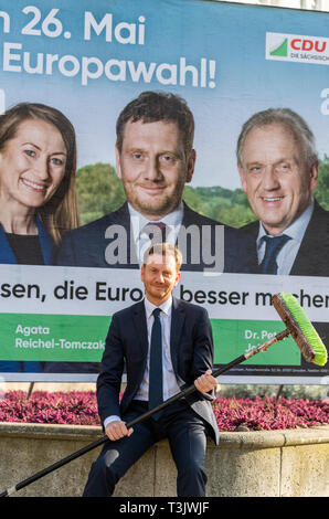 Dresden, Deutschland. 10 Apr, 2019. Michael Kretschmer (CDU), Ministerpräsident von Sachsen, sitzt mit einem Plakat Pinsel vor dem Plakat bei der Präsentation der neuen Wahlplakat der sächsischen CDU für die Wahlen zum Europäischen Parlament. Credit: Robert Michael/dpa-Zentralbild/ZB/dpa/Alamy leben Nachrichten Stockfoto